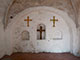 "Stufenbandkreuz" und "Schuppenkreuz", ein schlichtes Holzkreuz flankierend, Westwand der Sakristei, 2018 (Foto: J. Weyers)